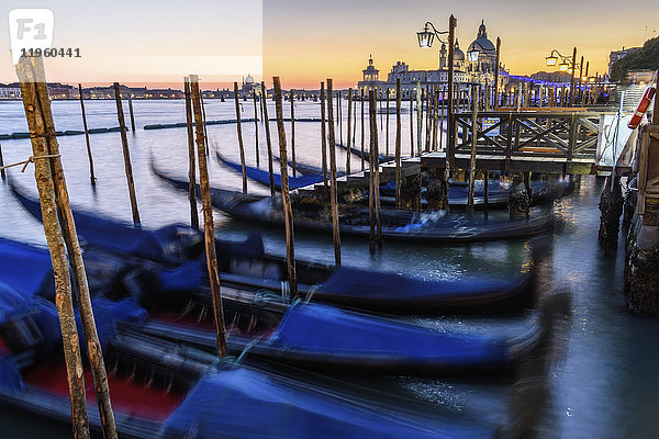 Gondeln vertäut auf einem Kanal in Venedig  Italien  bei Sonnenaufgang.