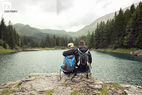 Rückansicht eines Wanderpaares  am See sitzend  Tirol  Steiermark  Österreich  Europa
