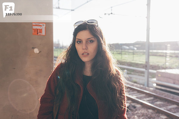 Porträt einer jungen Frau auf dem Bahnsteig stehend