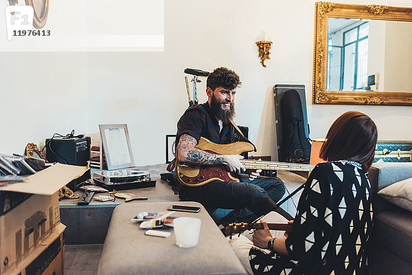 Paar spielt E-Gitarren in Wohnung