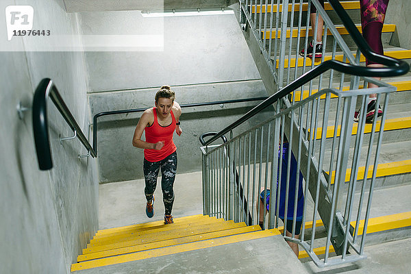 Junge weibliche Läuferin läuft die Treppe in der Halle hinauf