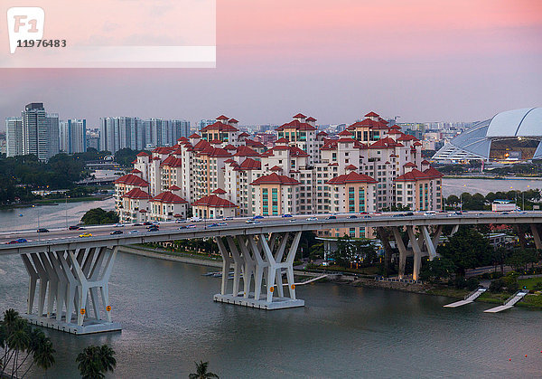 Erhöhtes Stadtbild mit Autobahnbrücke und Wohnanlagen in der Abenddämmerung  Singapur  Südostasien