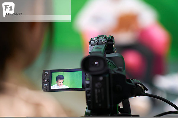 Über-Schulter-Ansicht von College-Studenten beim Üben im Fernsehstudio mit Green Screen