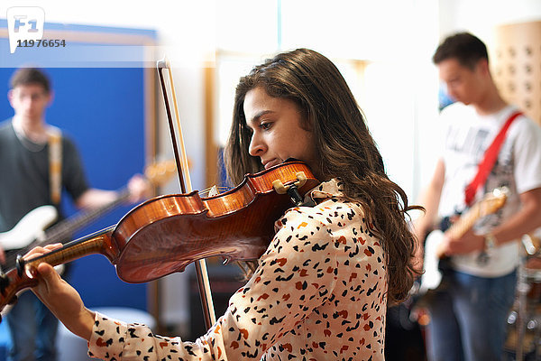 Junge Studentin spielt Geige im Aufnahmestudio