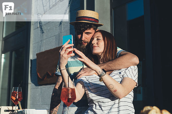 Ehepaar beim Selbstbedienungs-Smartphone im Straßencafé