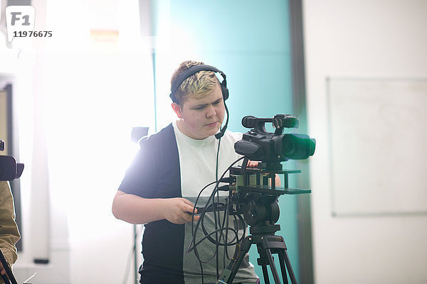 Junger männlicher Student beim Filmen im Fernsehstudio