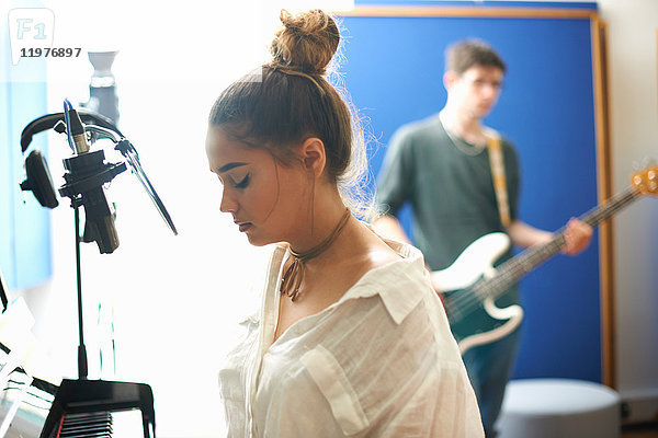 Junge Studentin bereitet sich im Aufnahmestudio auf das Singen vor