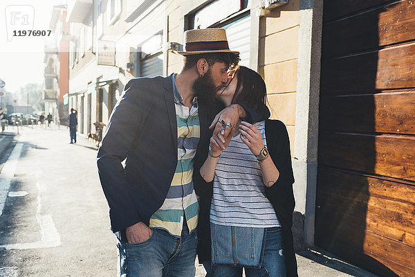 Romantisches Paar küsst sich auf sonnenbeschienener Straße