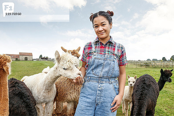 Porträt einer Frau mit Alpakas auf einem Bauernhof