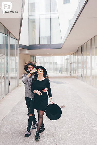 Junges Paar geht in städtischer Umgebung spazieren  albert herum  lacht