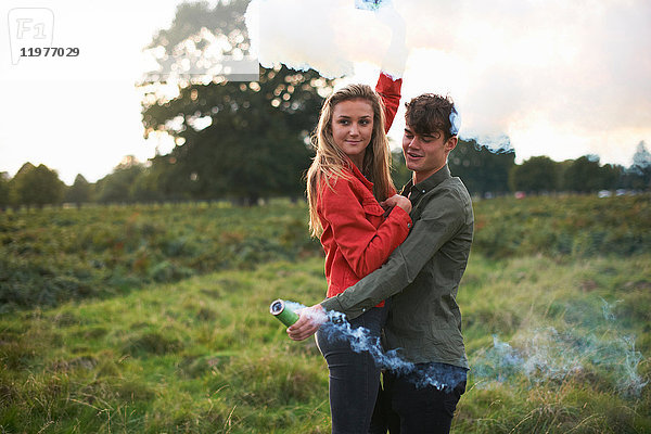 Junges Paar lässt auf dem Feld Rauchfahnen ab