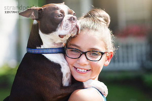 Porträt eines Mädchens mit Hund  das lächelnd in die Kamera schaut