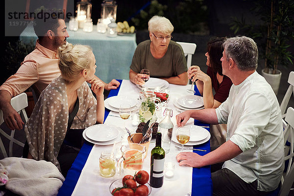 Gruppe von Personen  die am Tisch sitzen und eine Mahlzeit genießen