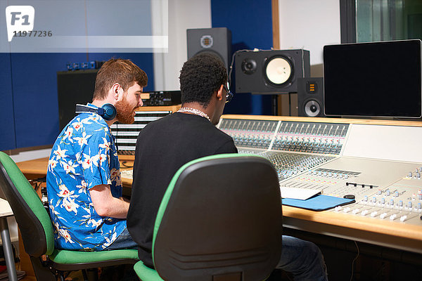 Zwei junge männliche College-Studenten am Tonmischpult im Tonstudio