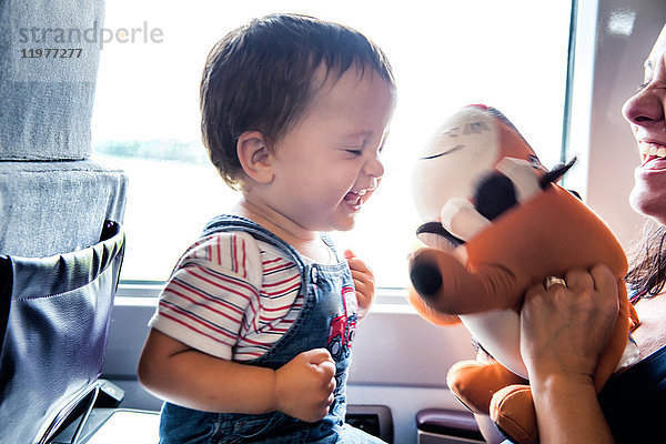 Mutter und kleiner Sohn reisen im Zug und spielen zusammen