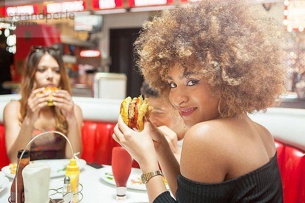 Drei junge Freunde sitzen im Diner und essen Burger