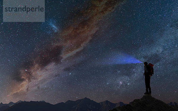 Silhouette eines Bergsteigers auf einem Berggipfel mit Blick in den Sternenhimmel  Chamonix  Mont Blanc  Rhone Alpes  Frankreich  Europa