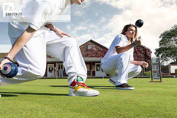 Abschlag von zwei jungen Männern beim Rasenbowling auf dem Bowling-Grün