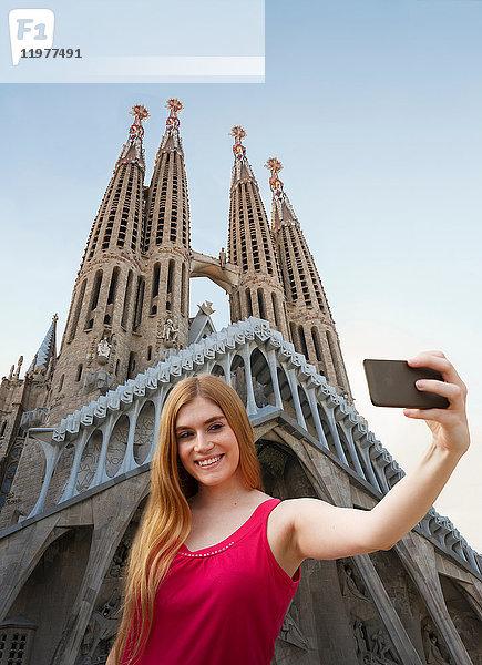 Frau nimmt sich vor der Kathedrale Sagrada familia selbst in die Hand  Barcelona  Katalonien  Spanien  Europa