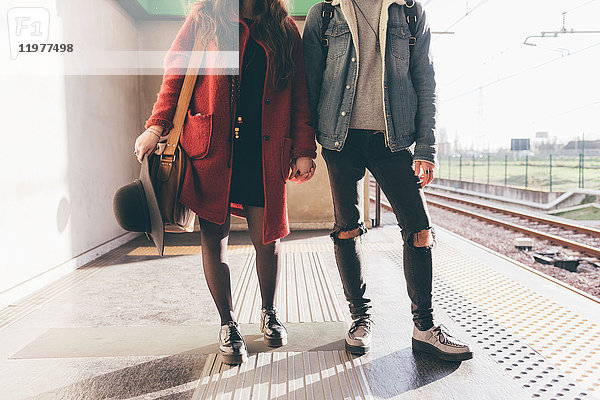 Porträt eines jungen Paares auf dem Bahnsteig  Unterteil