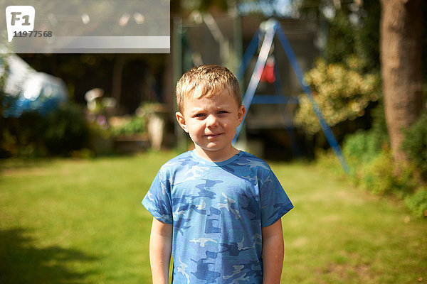 Porträt eines süßen Jungen im Garten stehend