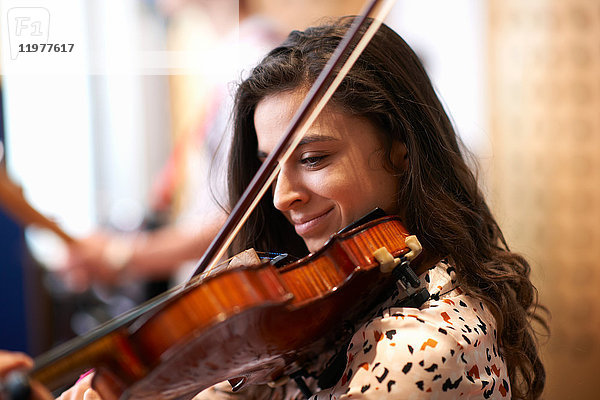 Junge Studentin spielt Geige im Aufnahmestudio