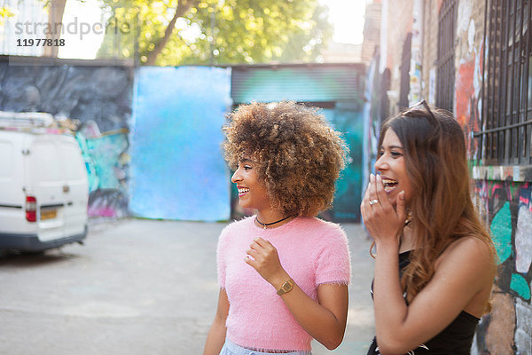 Zwei junge Frauen auf der Straße  wegschauend  lachend