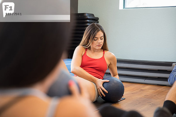Freunde trainieren mit Medizinball im Fitnessstudio