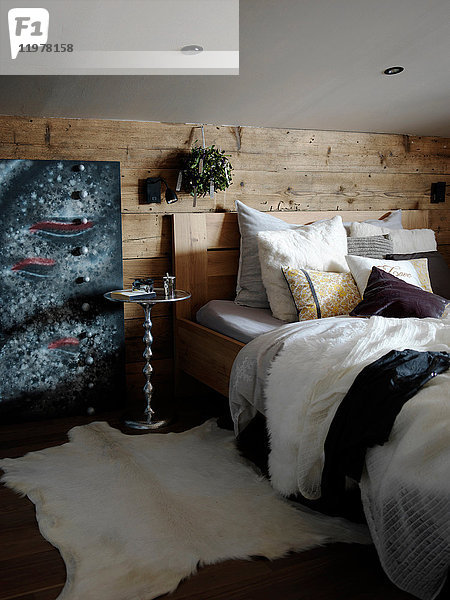 Schlafzimmer innen  holzverkleidete Wand hinter dem Bett