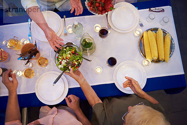 Gruppe von Personen am Tisch sitzend  gerade dabei  Essen zu servieren  Draufsicht