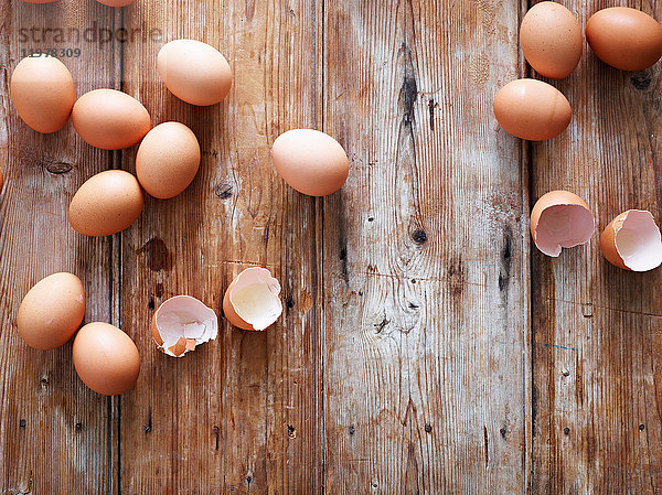 Eier und Eierschalen auf Holzoberfläche  Draufsicht