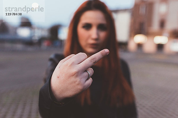 Frau zeigt Mittelfinger zur Kamera