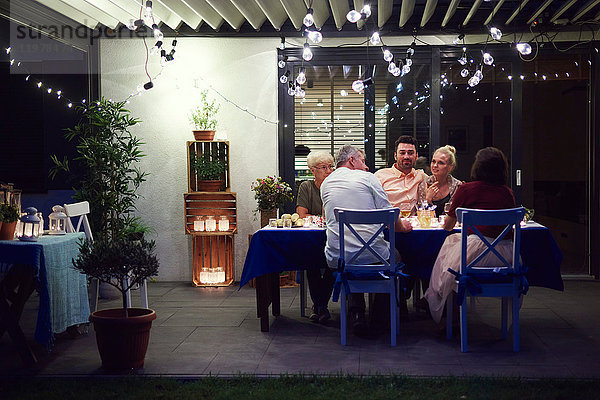 Gruppe von Personen  die am Tisch sitzen und eine Mahlzeit genießen