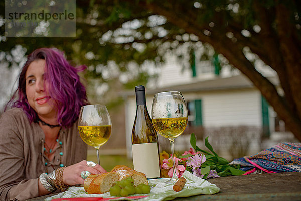 Frau entspannt sich mit Wein im Garten