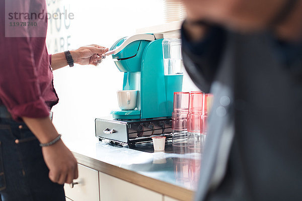 Schnappschuss eines Geschäftsmannes mit Kaffeemaschine