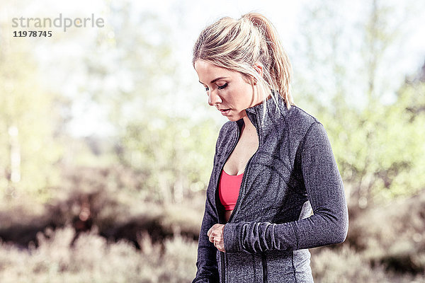 Junge Frau in ländlicher Umgebung  Sweatshirt mit Reißverschluss