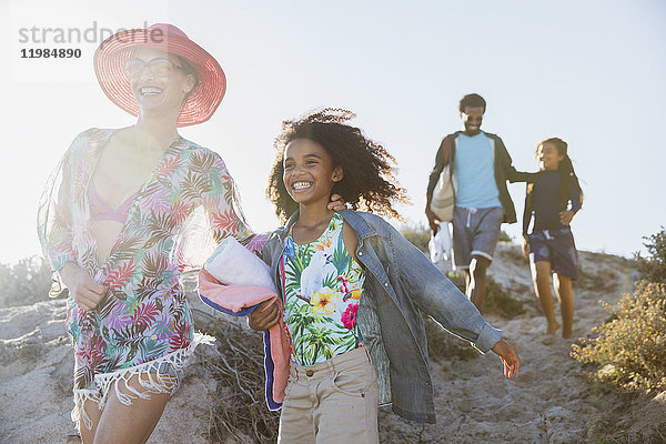 Lächelnder Familienspaziergang auf dem sonnigen Strandberg im Sommer