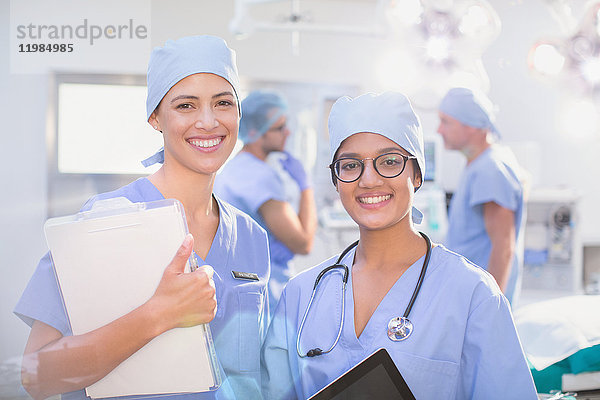 Portrait lächelnde  selbstbewusste Chirurginnen im Operationssaal