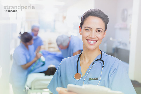 Porträt einer lächelnden  selbstbewussten Chirurgin mit Klemmbrett im Krankenhausflur
