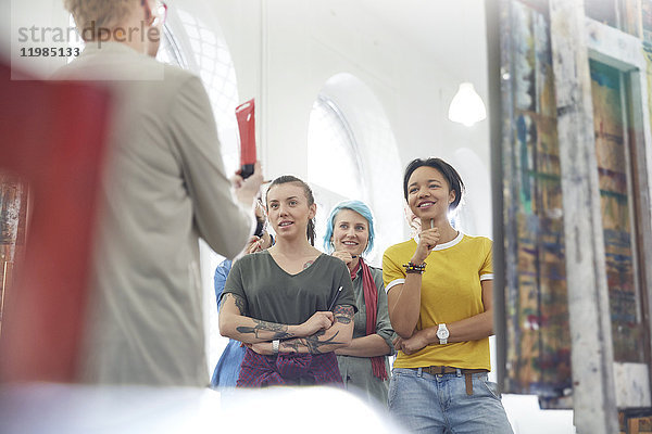 Schüler  die dem Lehrer im Kunststudio zuhören.