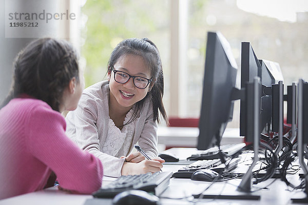 Lächelnde Schülerinnen forschen am Computer im Laborunterricht