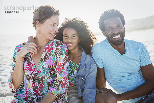 Portrait lächelnde  multiethnische Familie am sonnigen Sommerstrand