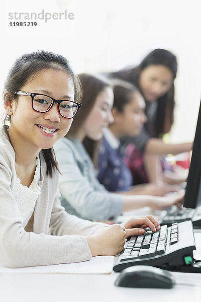 Portrait lächelnde Schülerin mit Computer im Computerlabor