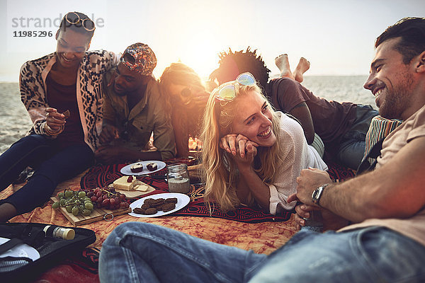 Junge Freunde beim Picknick am sonnigen Sommerstrand