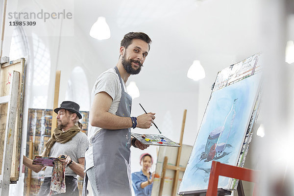 Porträt selbstbewusste männliche Malerei mit Palette im Atelier der Kunstklasse