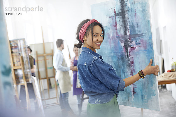 Portrait lächelnde Künstlerin beim Malen im Atelier der Kunstklasse