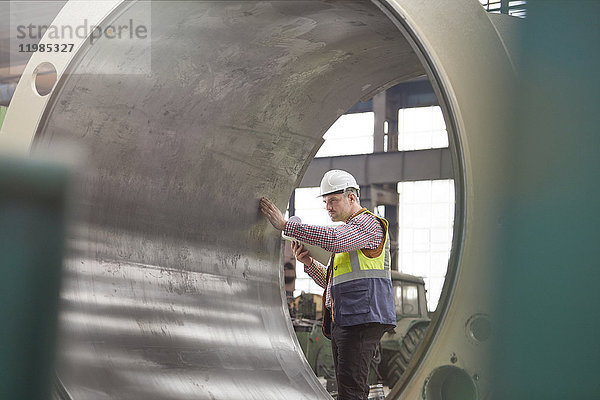 Ingenieur bei der Untersuchung großer Stahlzylinder im Werk