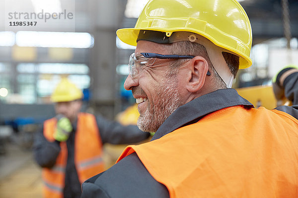 Profil lächelnder Arbeiter in der Fabrik