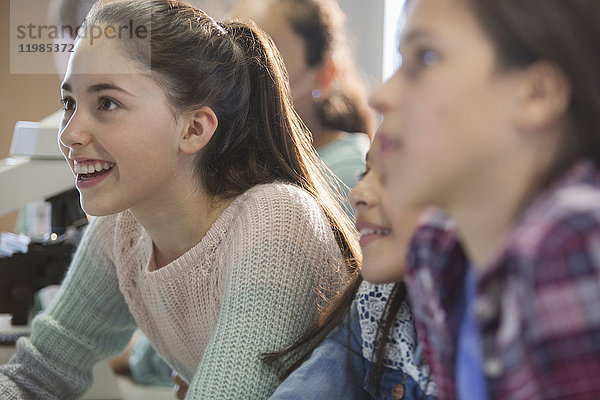 Neugierige  lächelnde Mädchen  die im Klassenzimmer zuhören.
