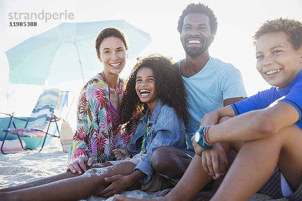 Portrait lächelnde  glückliche multiethnische Familie am Sommerstrand